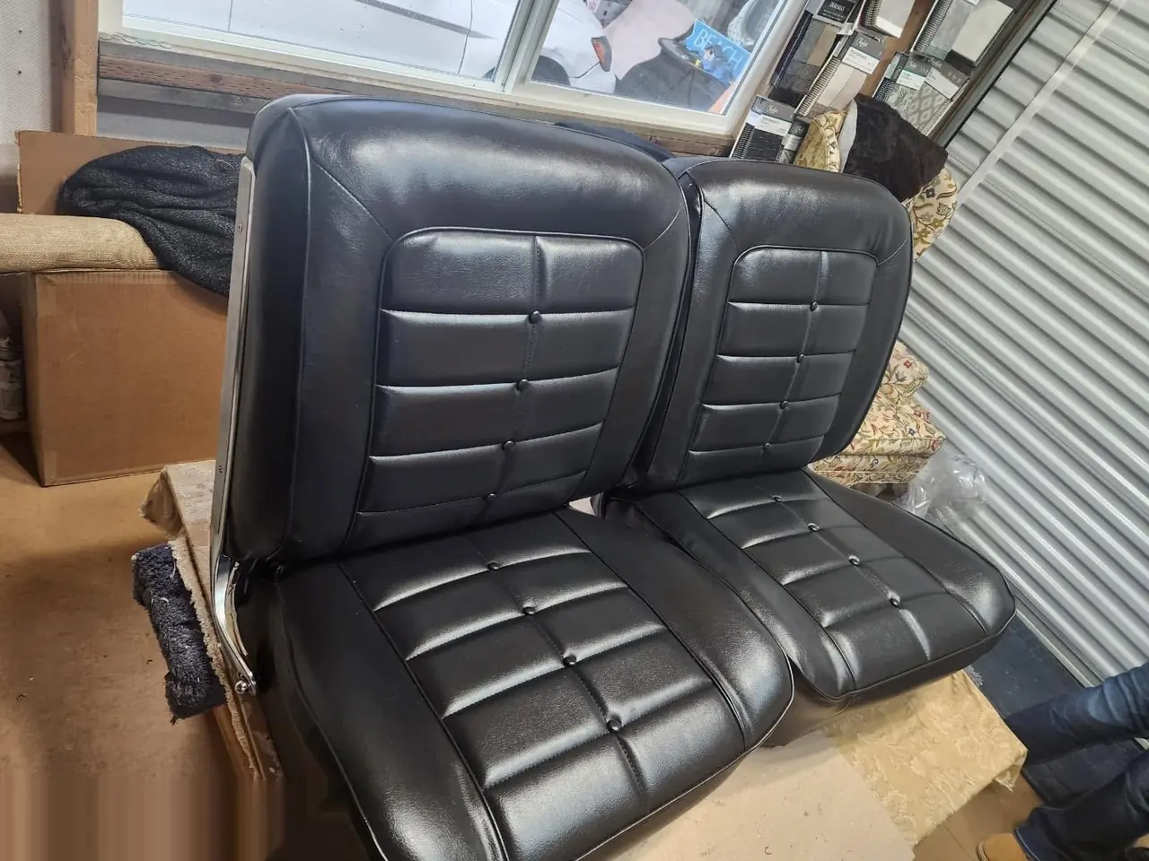 Pair of black quilted automotive bucket seats freshly upholstered.