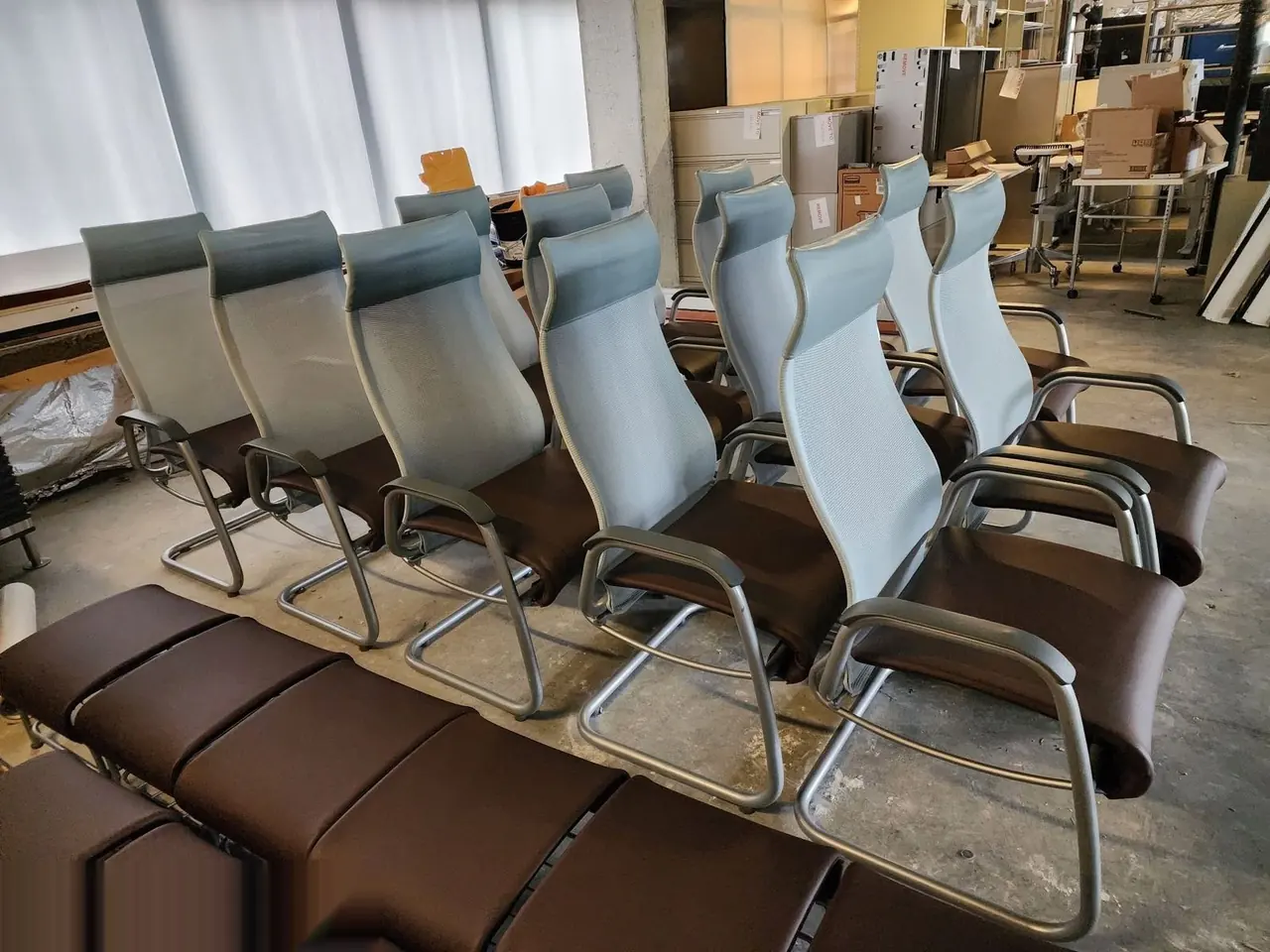 Row of wood-back restaurant chairs with brown vinyl seats reupholstered for a commercial dining space.