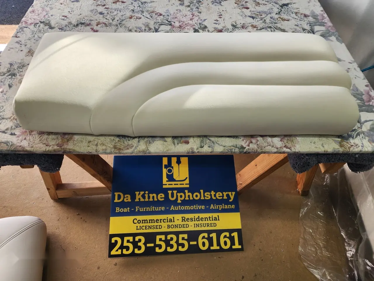 Curved boat bolster cushion reupholstered in cream marine vinyl.