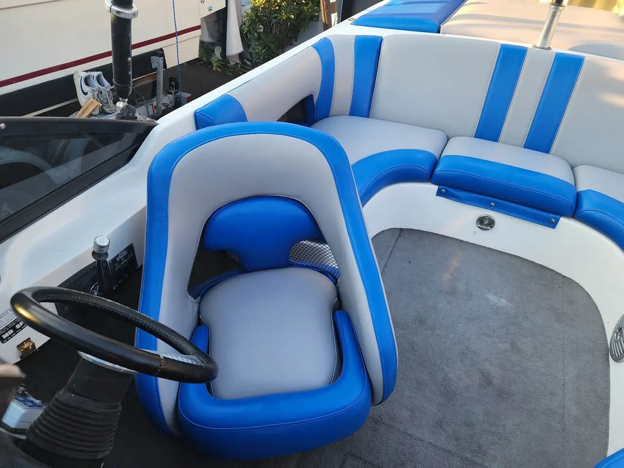 Wakeboard boat helm seat and console reupholstered in blue and gray marine vinyl.
