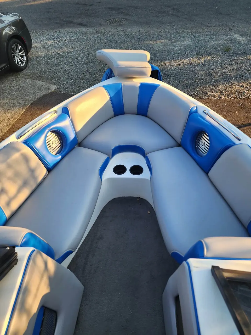 Boat bow seating reupholstered in blue and gray marine vinyl with cupholder console.