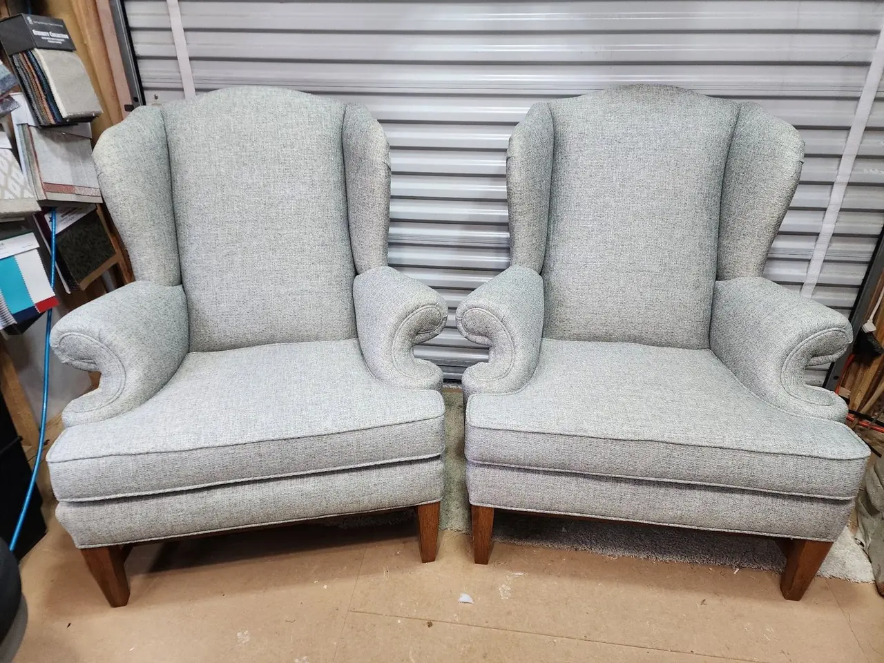 Wingback loveseat reupholstered in light gray tufted fabric.