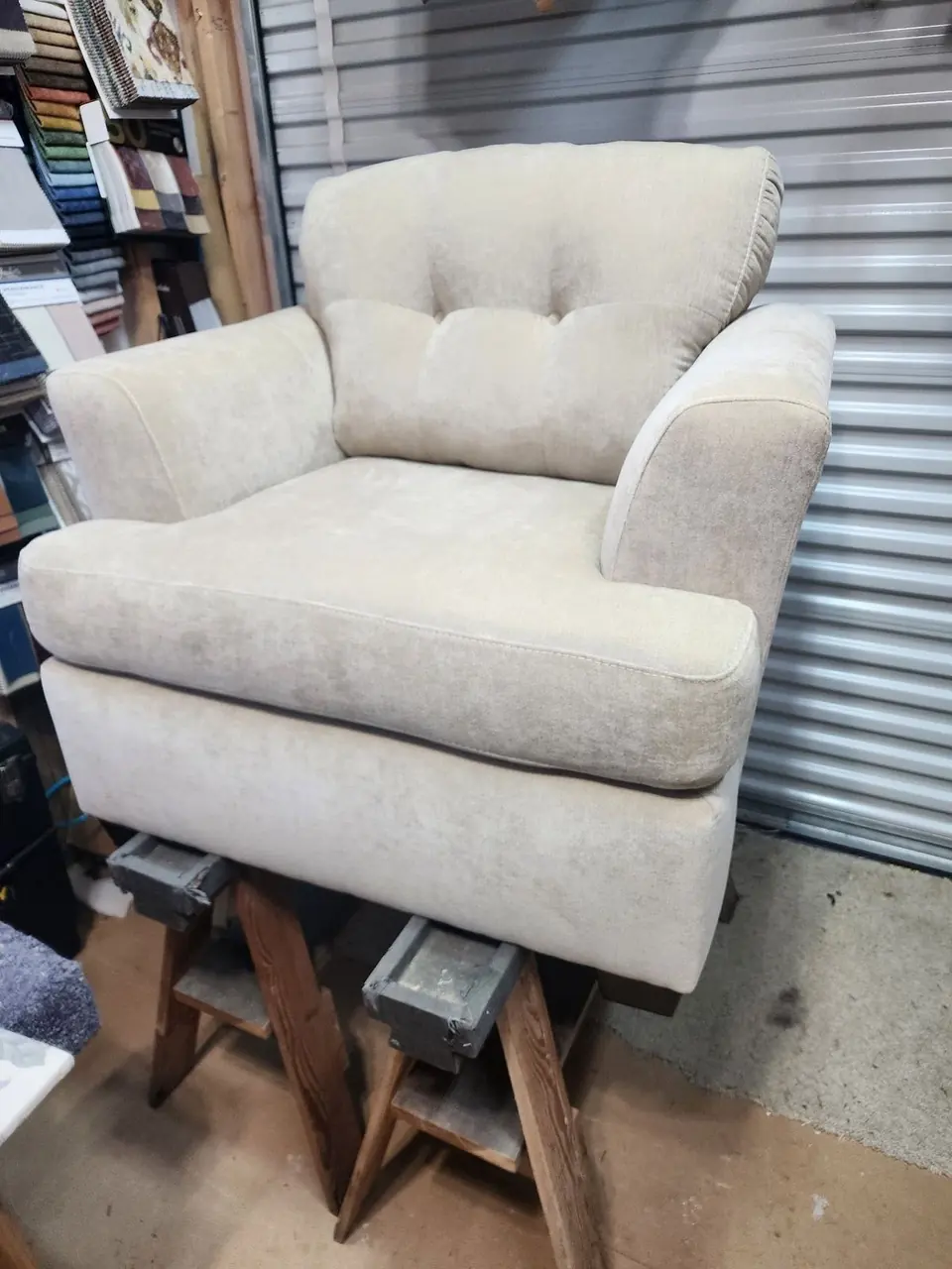 Club chair reupholstered in cream tufted fabric.