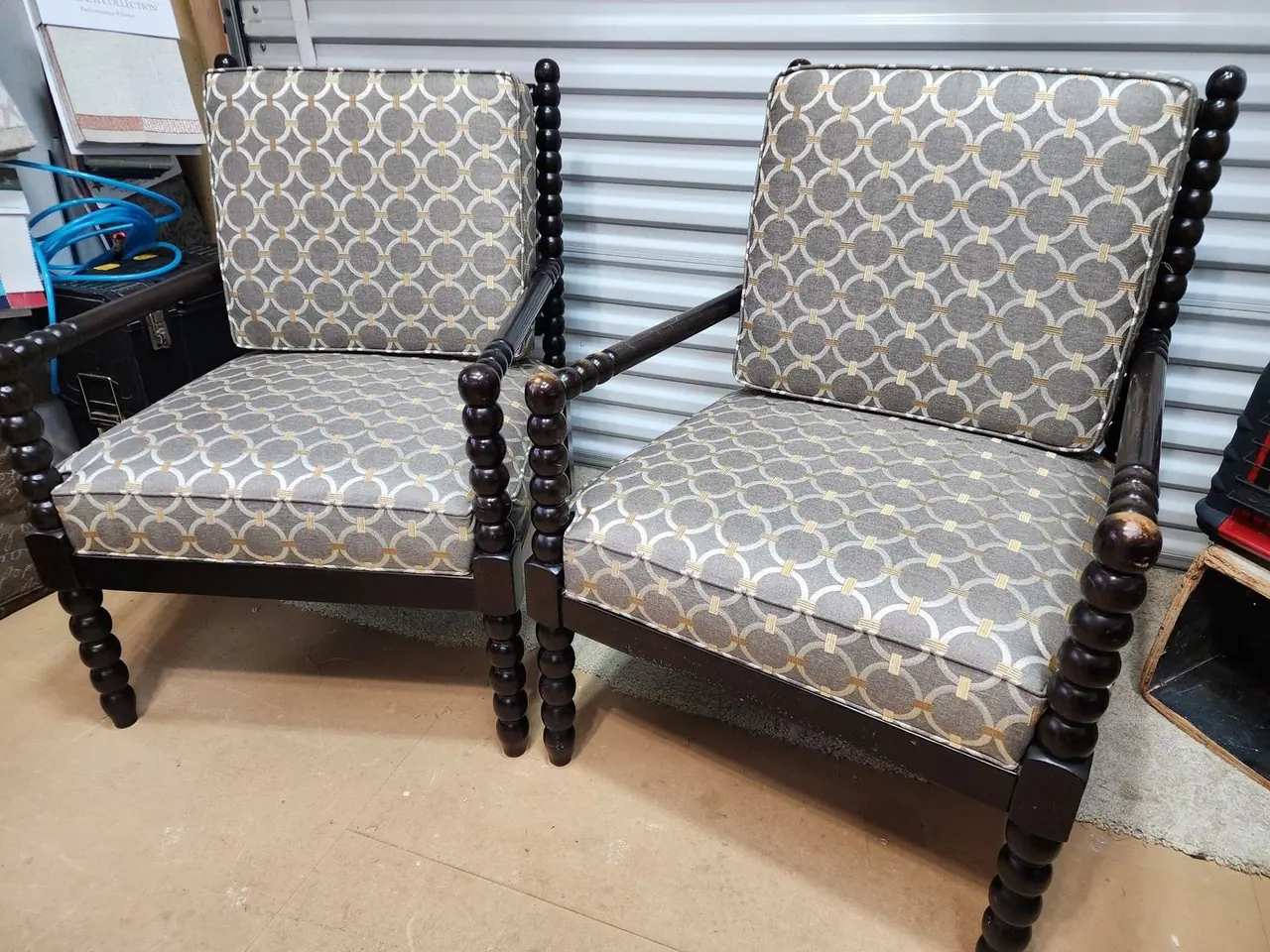 Pair of spool-leg accent chairs reupholstered in a gray and gold geometric pattern.
