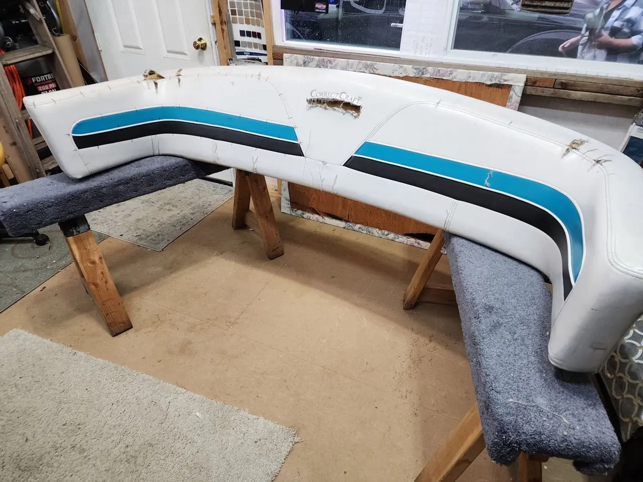Marine vinyl boat bolster with a frayed, torn corner before restoration.