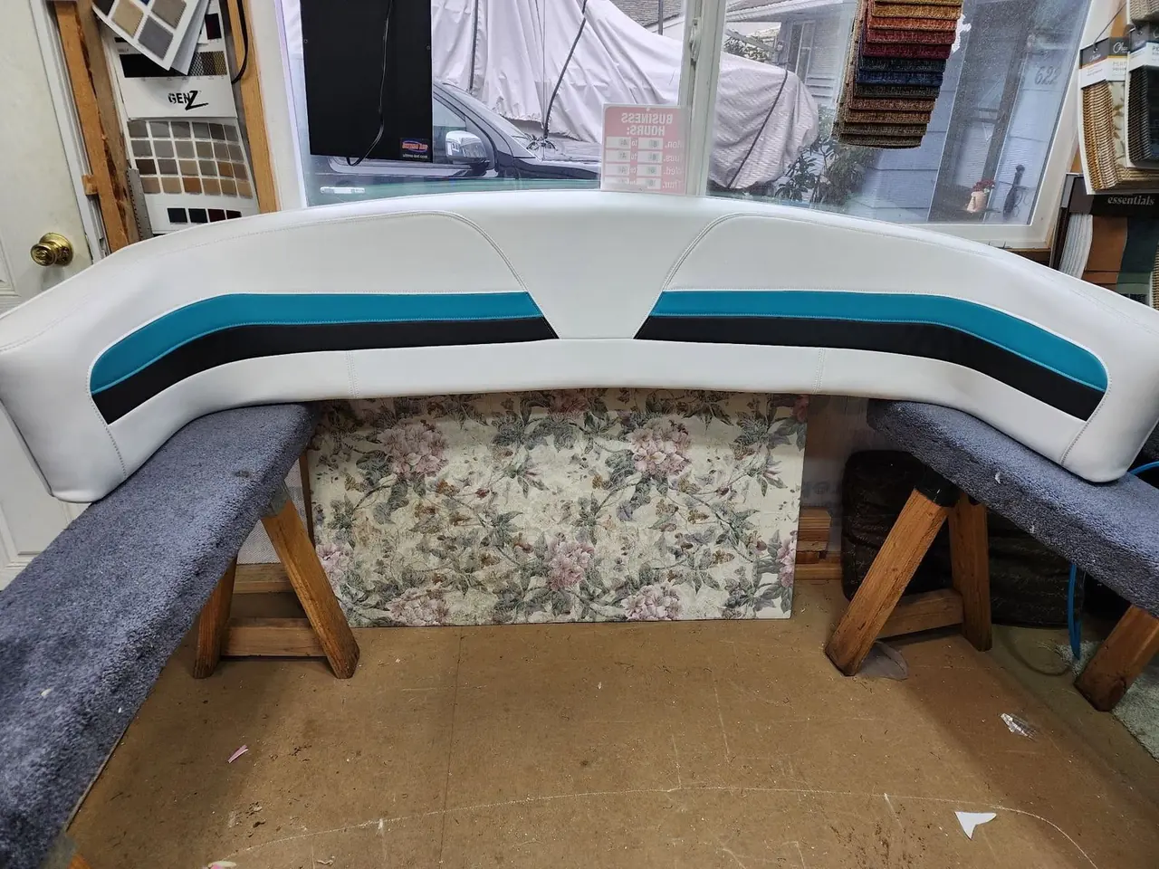 White marine vinyl boat bolster with a teal and black racing stripe, freshly upholstered.