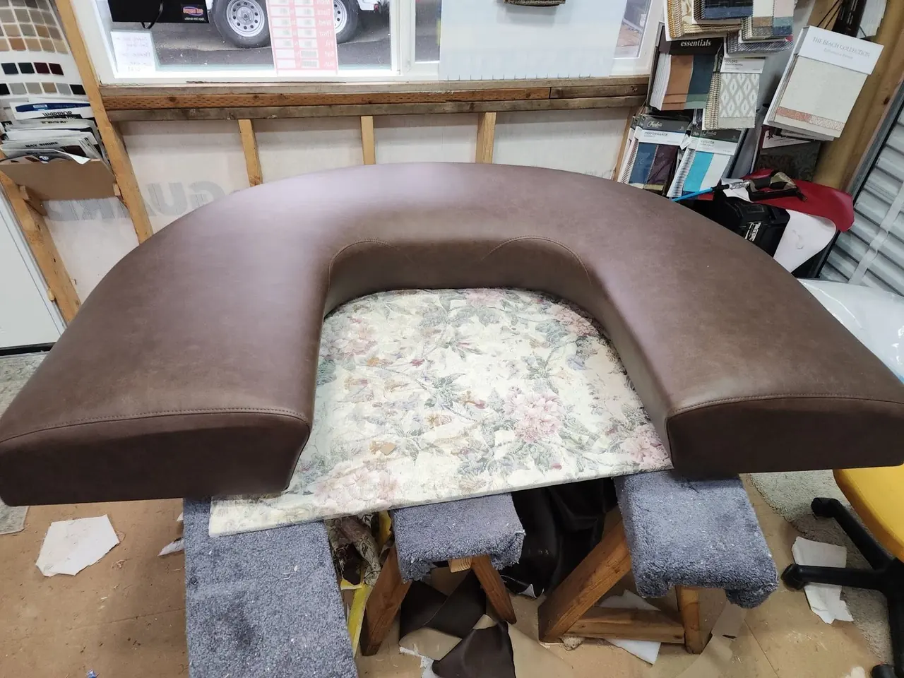 Curved restaurant booth bolster freshly upholstered in brown vinyl.