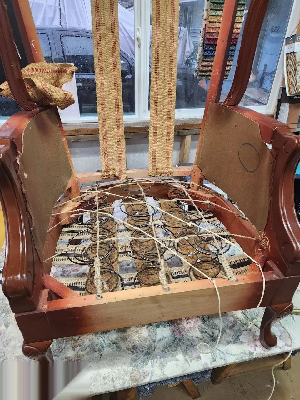 Close view of hand-tied coil springs and webbing on a stripped antique chair frame at Da Kine Upholstery