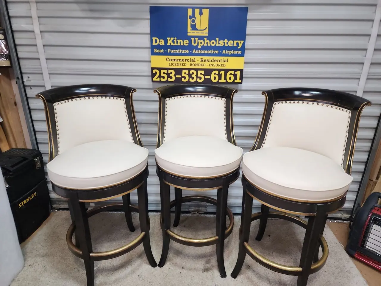 Set of bar stools with wood slat backs reupholstered in a cream and blue sunburst pattern.