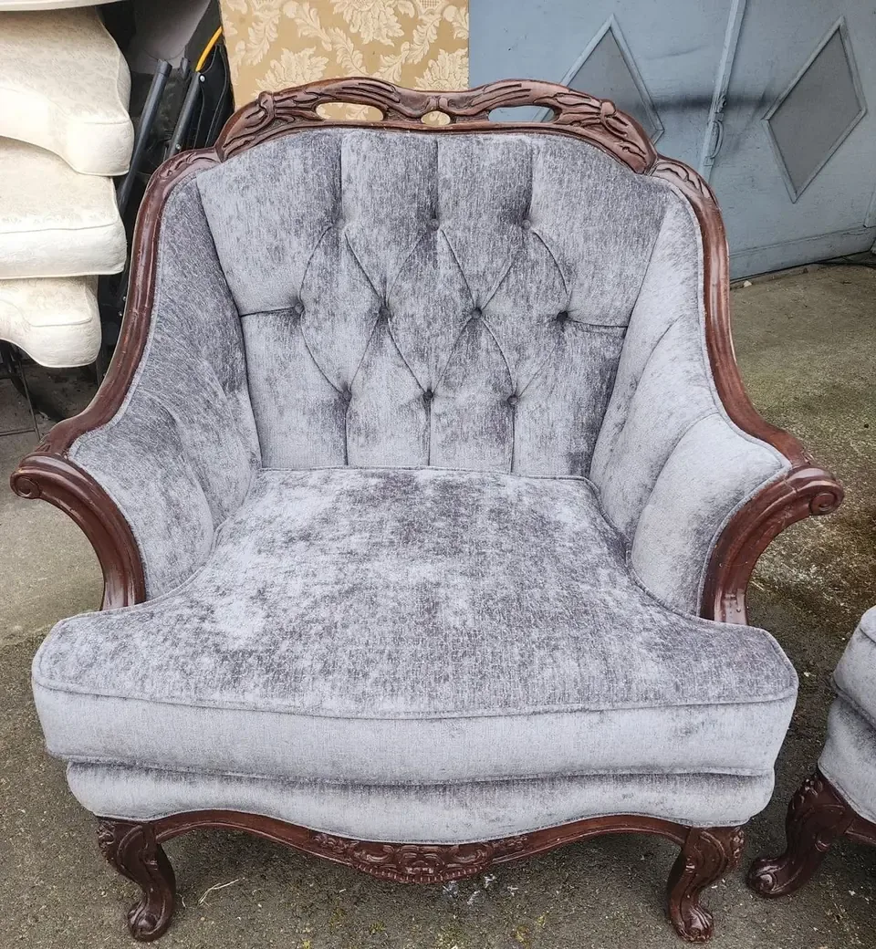 Antique wingback chair reupholstered in cream tufted fabric.