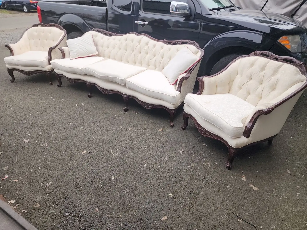 Worn antique sofa and armchair set in torn cream damask fabric before reupholstery