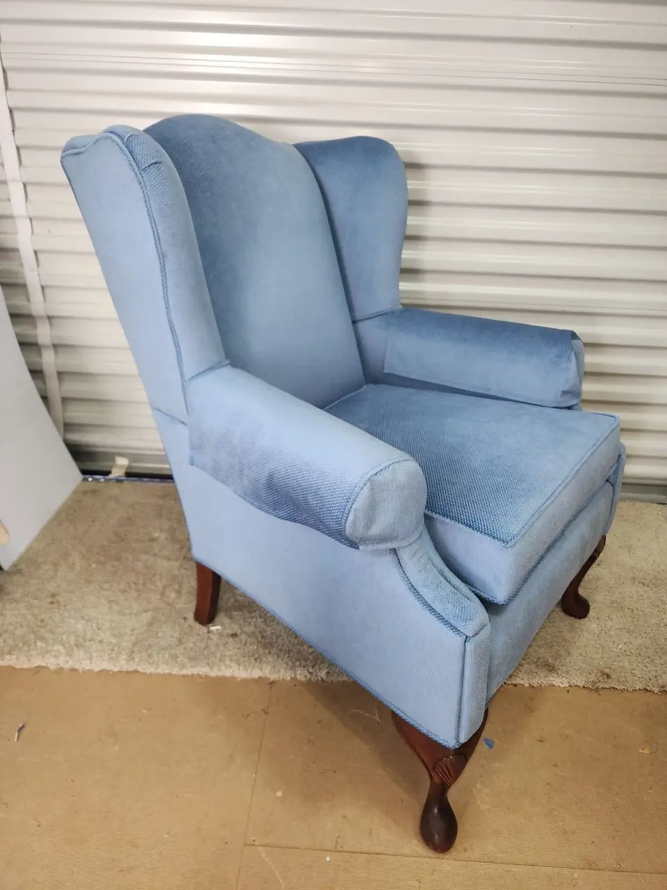 Wingback chair reupholstered in light blue fabric.