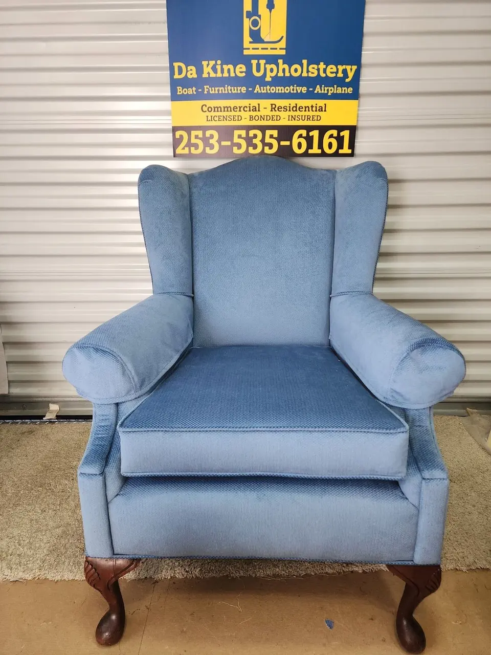 Wingback chair reupholstered in light blue fabric.