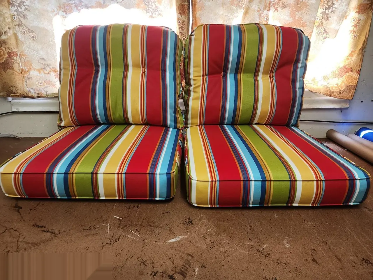 Set of outdoor cushions reupholstered in a bold red, green, yellow, and blue stripe.