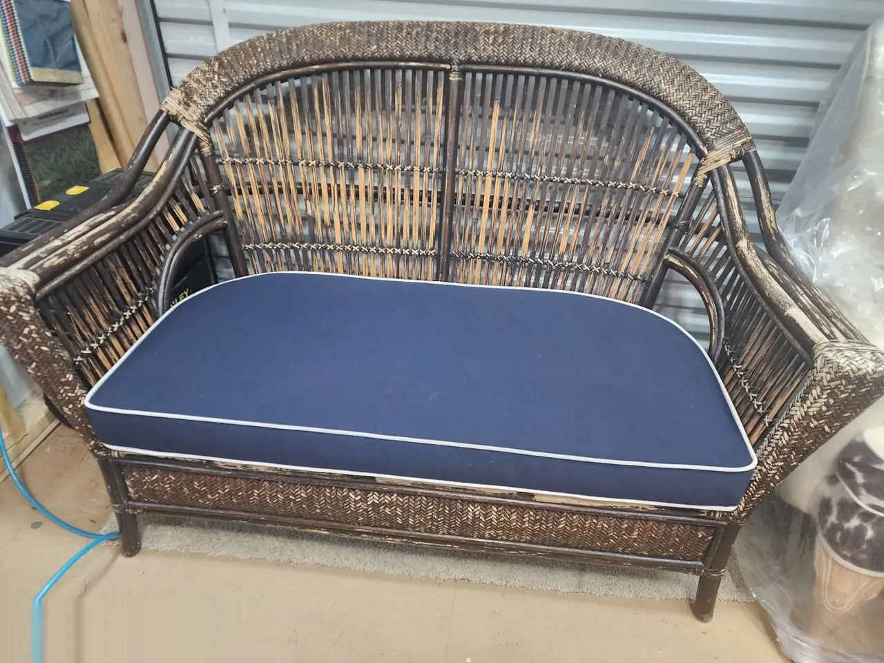 Restored wicker loveseat with a new custom navy blue cushion.