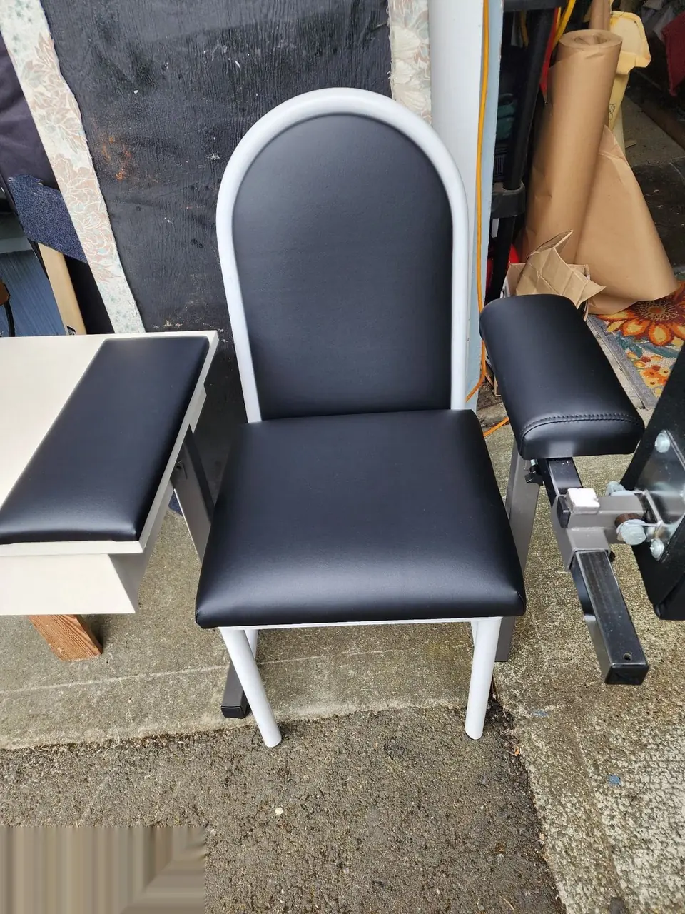 Black and white salon or spa chair reupholstered with a new armrest.