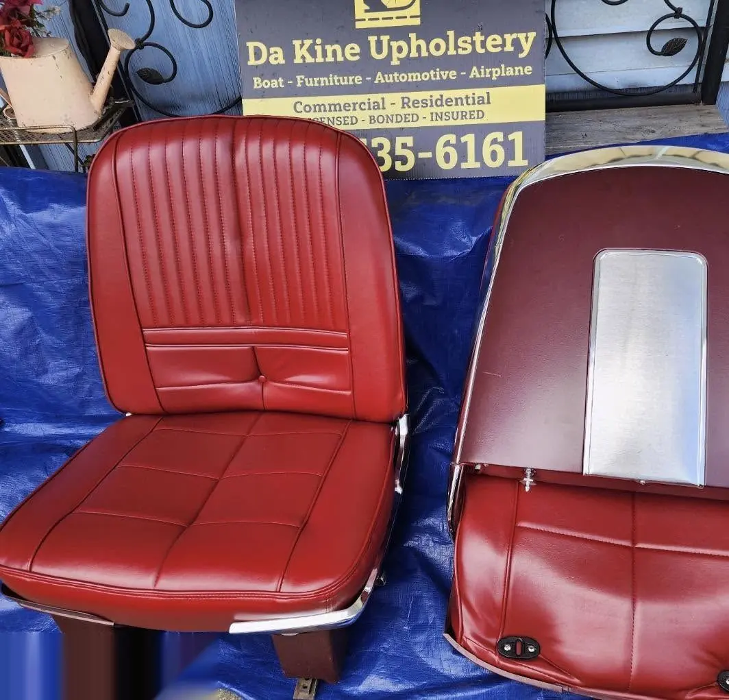 Pair of classic car bucket seats reupholstered in red and black leather.