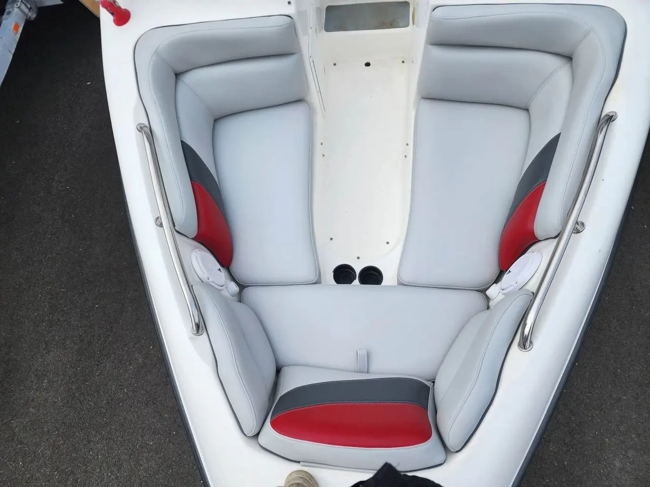 Overhead view of finished boat bow seating in white, gray, and red marine vinyl.