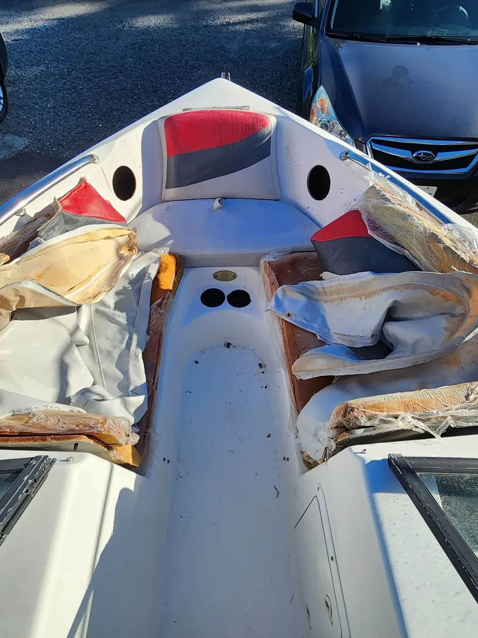 Gutted Tigé wakeboard boat interior with torn cushions before restoration.