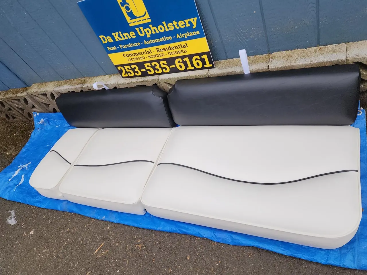 Boat bench seat reupholstered in white and black marine vinyl.